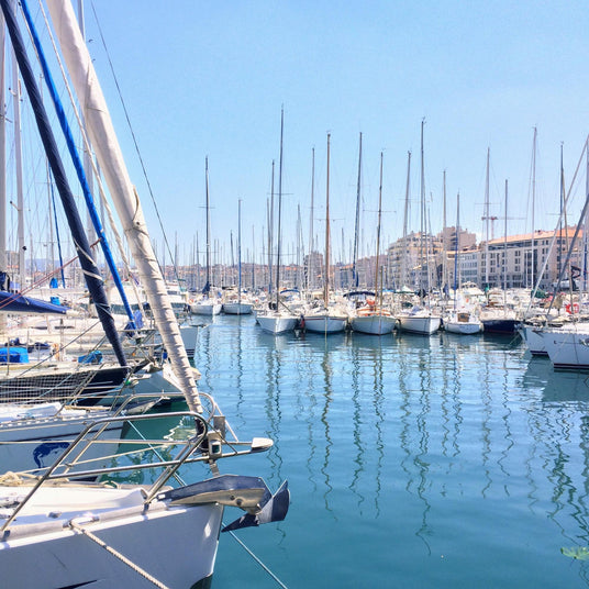 sailboats-moored-harbor-against-clear-sky